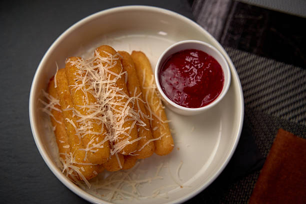 Deliciously Crispy Cheese Sticks Drizzled with Savory Parmesan and Served with a Tangy Tomato Dipping Sauce for a Flavorful Snack Experience