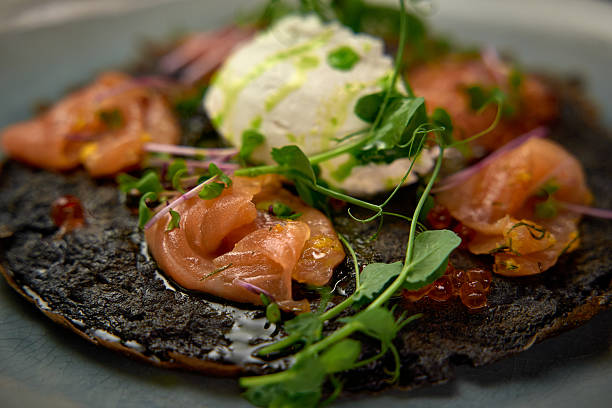 istock A Gourmet Dish Featuring Delicately Prepared Salmon on a Unique Black Base Topped with Fresh Cream and Microgreens for an Exquisite Culinary Experience 2227035200