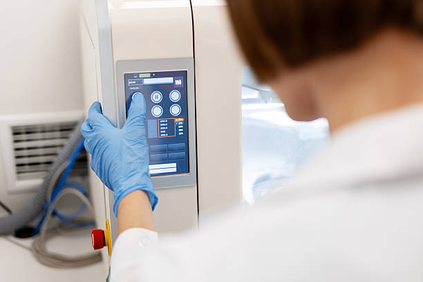 istock Scientist pushing button on control panel of medical equipment 2227037141