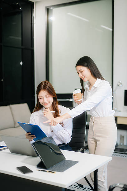 istock Two business workers talking on the smartphone and using laptop at the office. 2227037197