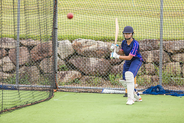 Teenage girl cricket player practicing batting
