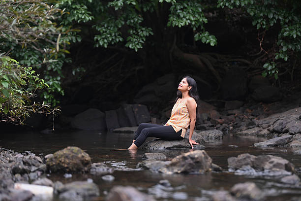 istock Woman Relaxing on Rock in Tranquil Forest Stream 2227051751