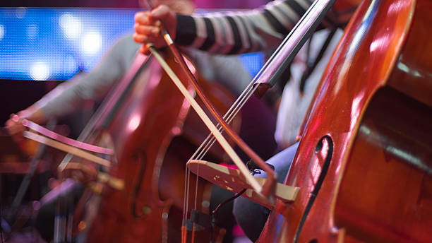 istock girl playing cello in orchestra on stage 2227052497