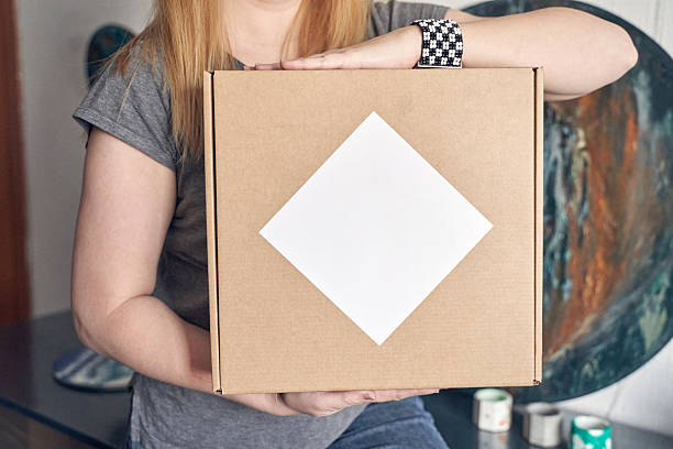 A family enjoys a creative moment as parents assist their daughter in making and wearing a decorated cardboard costume at home.