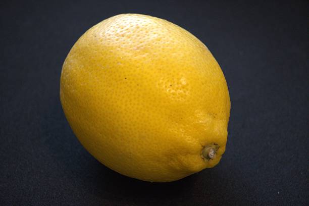 istock Single lemon isolated on black background with copy space. Fresh citrus fruit in dramatic lighting. 2227059566