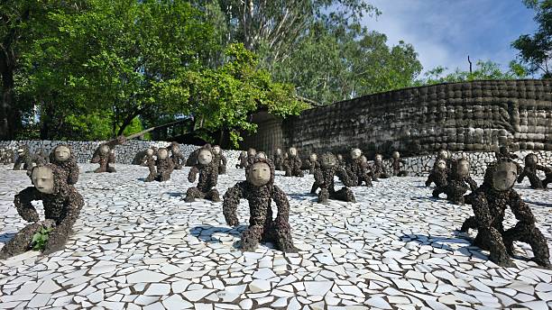 Chandigarh, India—July 15, 2025: Pebbled primate figures crawl forward across broken tile ground at Rock Garden.