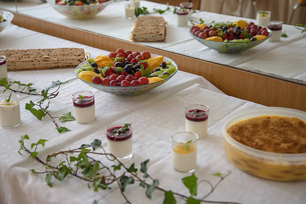 istock Assorted homemade desserts and fresh fruit are beautifully arranged on a white tablecloth during a festive indoor gathering, likely a celebration or family event, in a decorated dining area. 2227070084