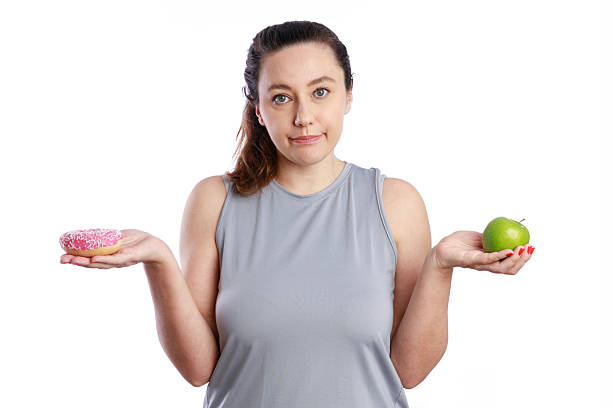 istock Choosing between doughnut and apple. Good nutrition for a healthy body 2227070964