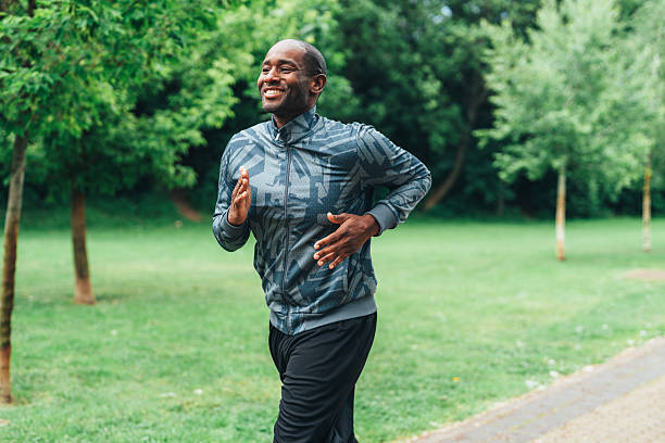 istock Smiling man jogging outdoors in the park. 2227074840