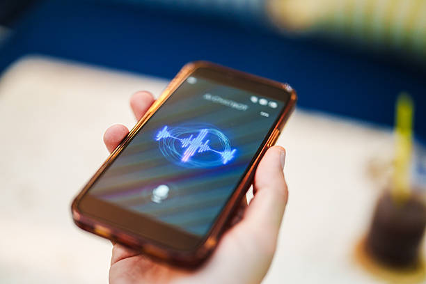 Close-up of a person using a voice assistant feature on her smartphone. The mobile screen displays a listening interface, indicating active voice command input.