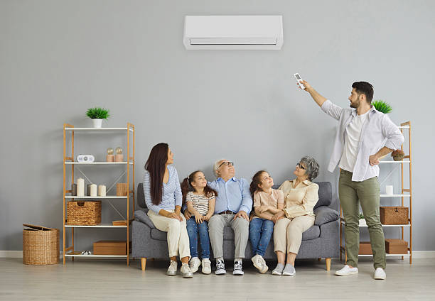 istock Man holding a remote control air conditioner makes a comfortable temperature for the family. 2227075401