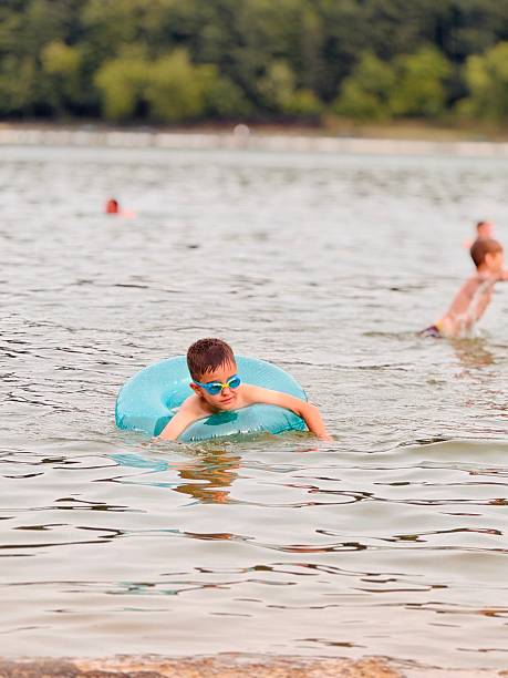 istock Boy in a Lake with a Blue Buoy 2227081040