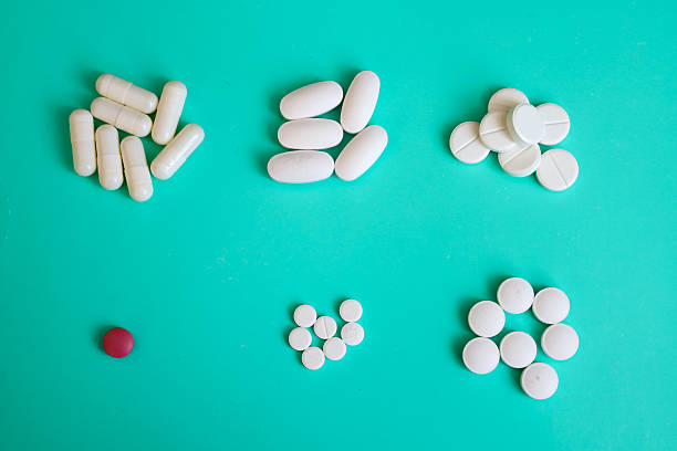 istock Various white tablets and capsules, along with one red one, are arranged on a turquoise background. This composition highlights the assortment of medications, symbolizing choice and individual needs in healthcare. 2227081272