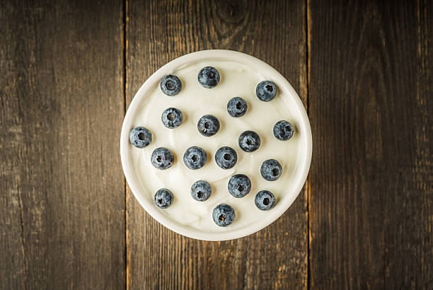 istock Fresh ripe blueberries on the white plain yogurt. Healthy desserts. 2227083562