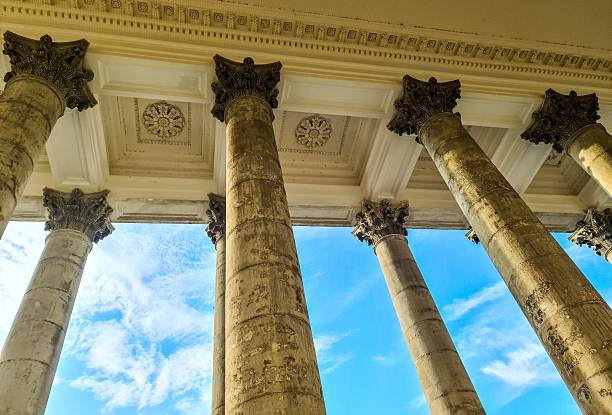 Fluted columns supporting an ornate ceiling reach towards a vibrant blue sky, showcasing architectural grandeur and classical design