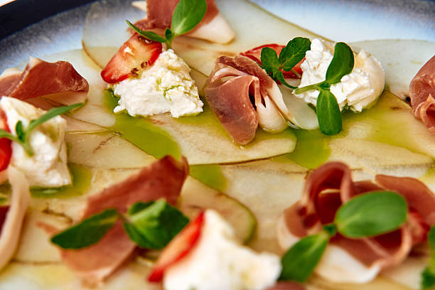 istock A Gourmet Dish Featuring Thinly Sliced Pears, Savory Prosciutto, Creamy Cheese, and Fresh Herbs on a Beautifully Styled Plate 2227087162
