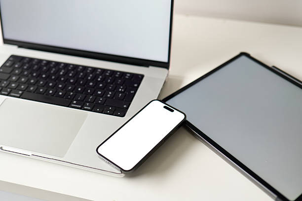 istock Laptop, tablet and smartphone are lying on white desk with blank screens 2227087256