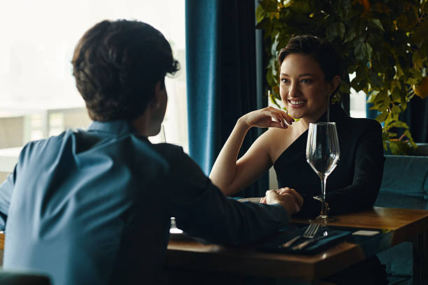istock Young Caucasian Woman Smiling While Holding Hands with Young Man at Restaurant 2227087623