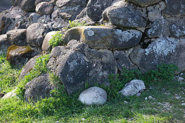 istock Stone wall adorned with moss and grass near ancient ruins in a tranquil natural setting 2227088881