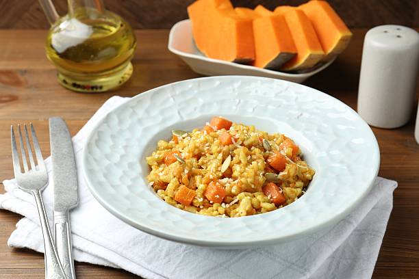 istock Delicious pumpkin risotto served on wooden table 2227093381