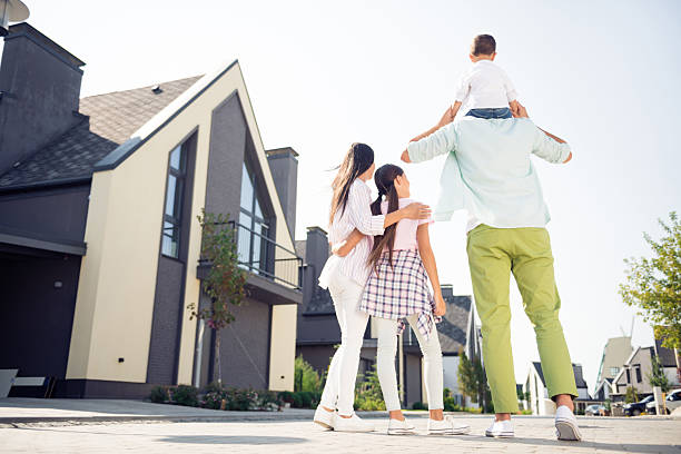 Full length body size rear back behind view of nice adorable family walking having fun playing dad carrying son in cottage town outdoor stock photo