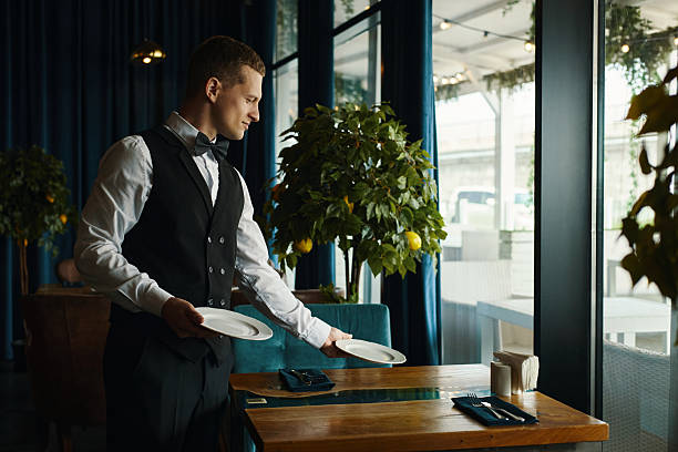 istock Young Caucasian Man Clearing Table While Working as Waiter in Restaurant 2227094312
