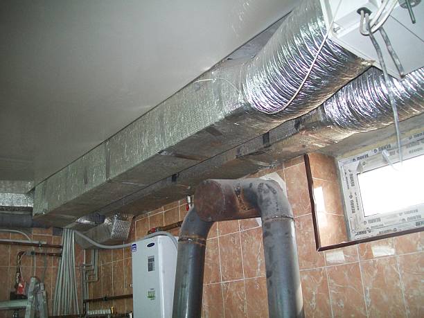 istock Ductwork system showing ventilation and exhaust pipes in a basement setting during daylight hours 2227096686