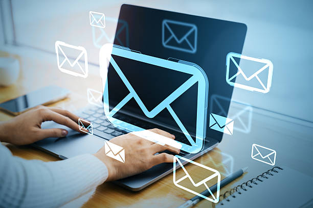 istock Digital email communication concept with envelope icons over laptop screen on modern office desk background with hands typing on keyboard. 2227096843