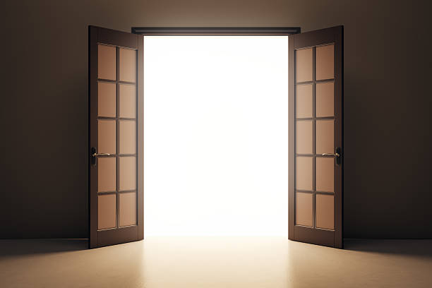 istock Open double doors revealing bright white light in dark room interior, symbolizing opportunity, hope, or transition concept background. 3D Rendering 2227097031