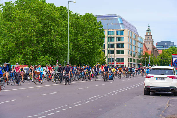 Berlin, Germany - June 1, 2025: Crowd of cyclists riding along a wide city road, surrounded by urban buildings and greenery, capturing a vibrant and active day in Berlin.