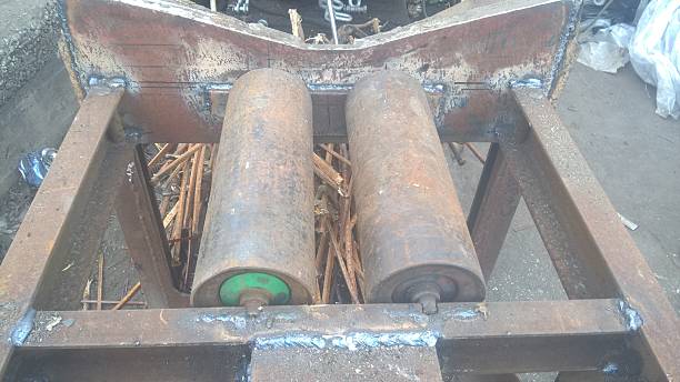 istock Machine parts in a workshop showcasing two rollers on a metal frame during daylight hours 2227098419