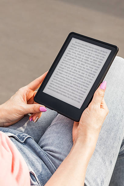 istock woman reading e-book sitting on bench, vertical photo 2227099889