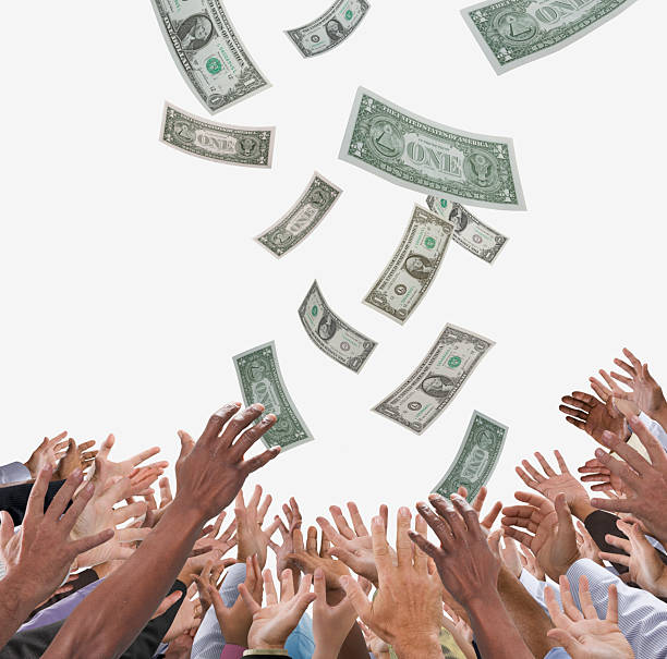 Conceptual image of crowd of people reaching for American dollars falling from sky