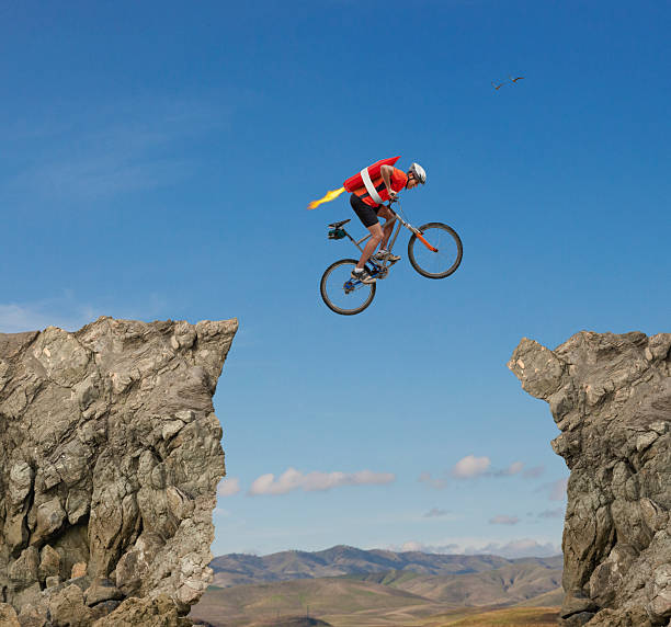 Conceptual image of road biker with rocket mid-air over gap