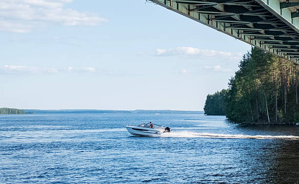 July 18, 2025 Finland Päijät-Häme region. Karisalmi bridge on Lake Päijänne. A high-speed motorboat sails under the bridge.