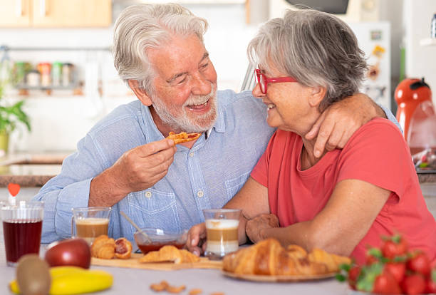 istock Attractive bonding senior Caucasian couple smiling while having breakfast at home. Relaxed and happy seniors enjoying healthy nutrition 2227109061