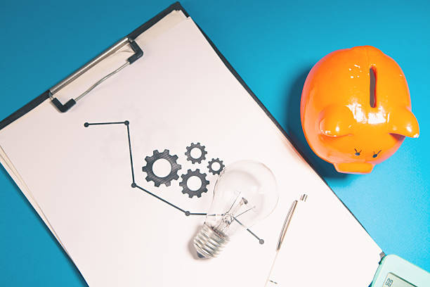 light bulb with notebook, glasses, pen and paper