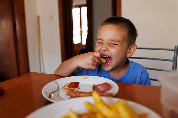 istock Cute little boy having breakfast at home 2227111646