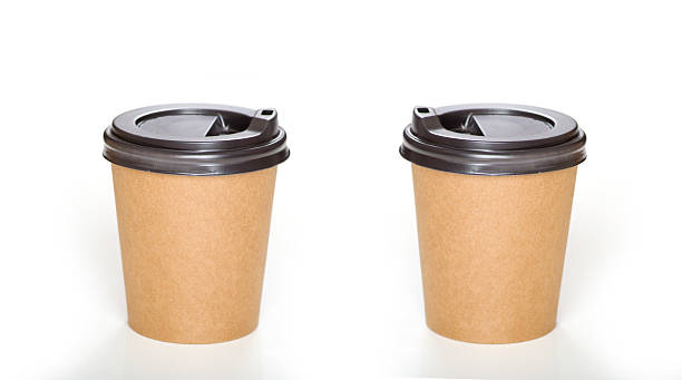 Two brown paper cup with black plastic lid for hot drinks on white background.