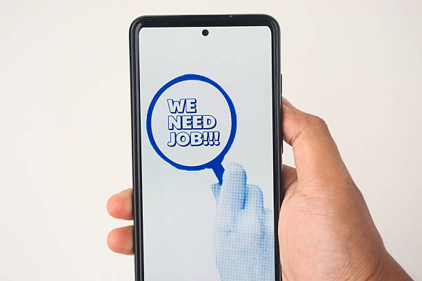 istock Hand Holding Smartphone Displaying 'We Need Job' Message on Screen 2227118806
