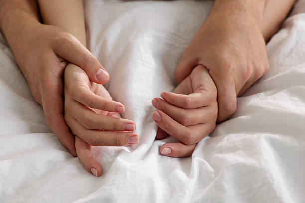 istock Lovely couple holding hands in bed, closeup 2227118833