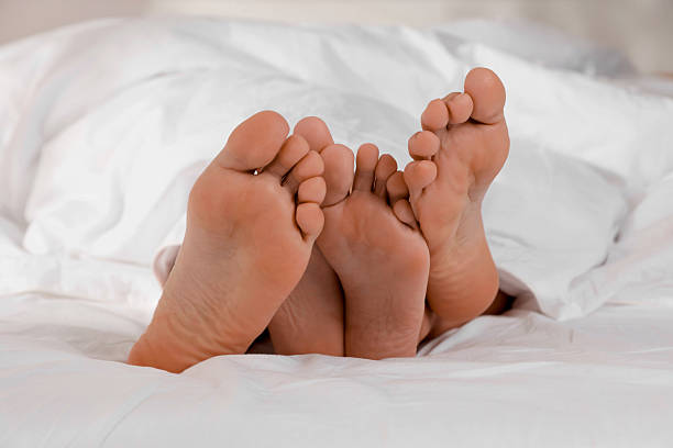 istock Couple lying in bed with white sheets, closeup 2227118865