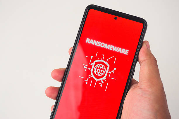 istock Smartphone Displaying Ransomware Warning with Red Background and Symbolic Graphics 2227119084