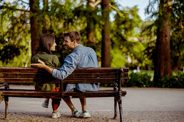 istock Romantic Couple Chatting on Bench in Sunny Park 2227120888