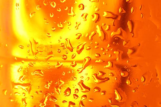 Water drops on orange glass surface, macro view
