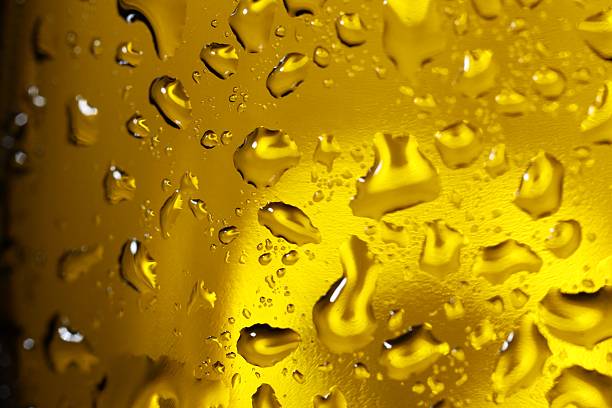Water drops on dark yellow glass surface, macro view