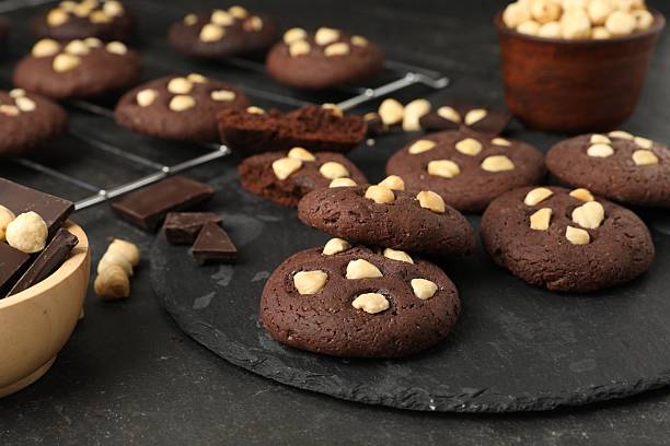 istock Tasty chocolate cookies with hazelnuts on black table, closeup 2227122093