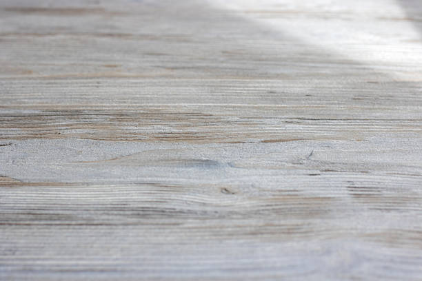 A detailed view of a piece of wood displaying a beautiful grain pattern, suitable for flooring or furniture. Keywords Brown, Wood, Flooring, Hardwood, Closeup, Pattern