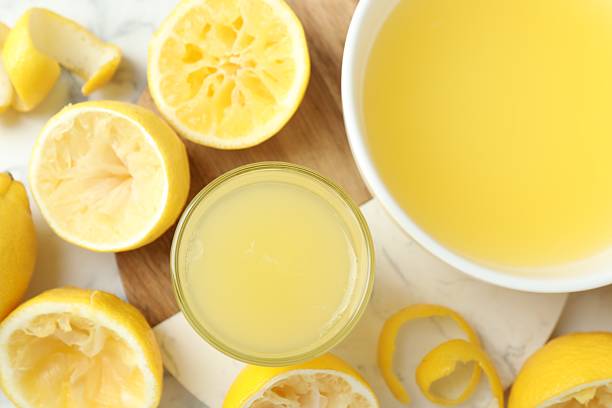 istock Fresh lemon juice and squeezed fruits on table, flat lay 2227122734