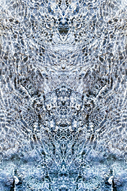 istock Silver colored abstract design obtained from symmetrical vertical reflection of glare of flowing water in a stream 2227122792